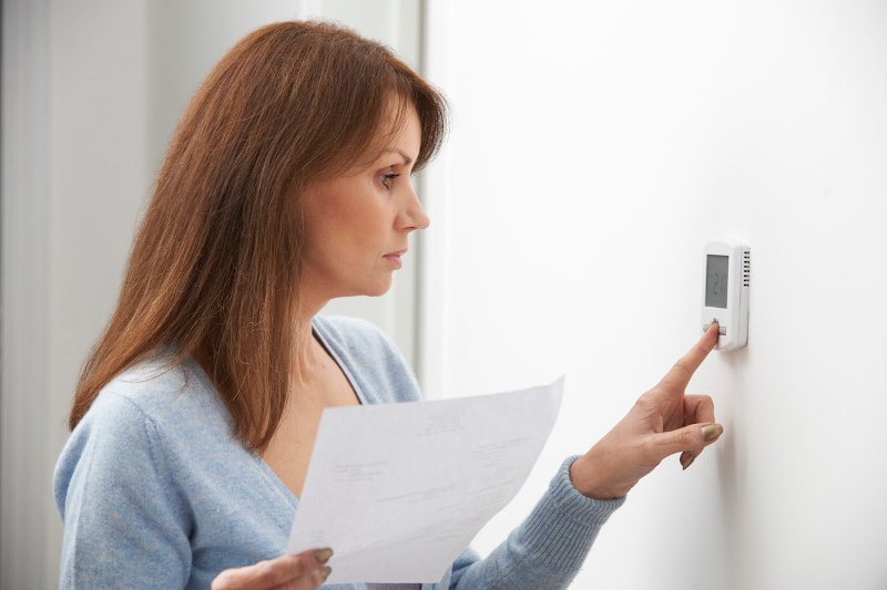 Woman Troubleshooting Blank Thermostat Screen